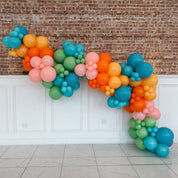 Colorful balloon garland against a brick wall