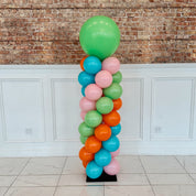 Colorful balloon column against a brick wall